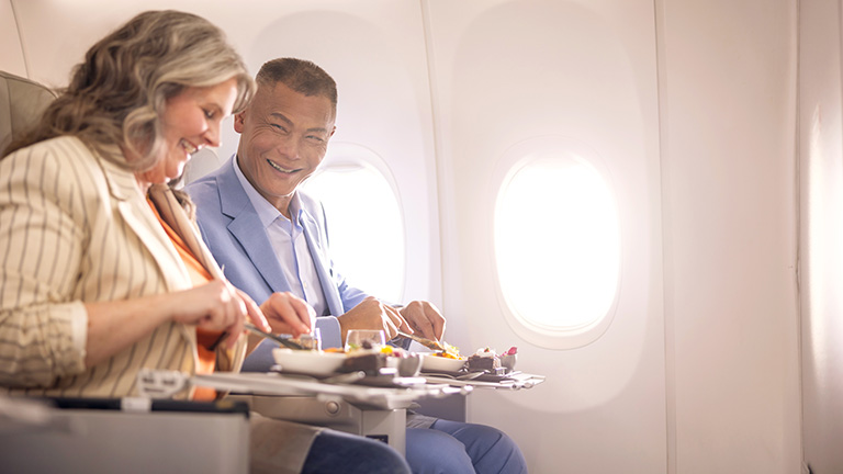 Invitados que cenan en la cabina Premium de WestJet a bordo del Dreamliner 787