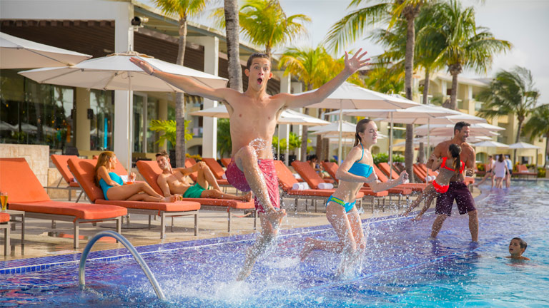 Guests jumping in the pool at Palace Resorts