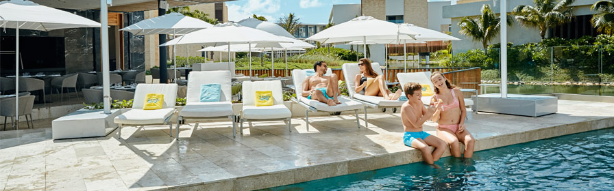 Une famille profite de l’aire de la piscine du Grand Palladium Costa Mujeres Resort & Spa
