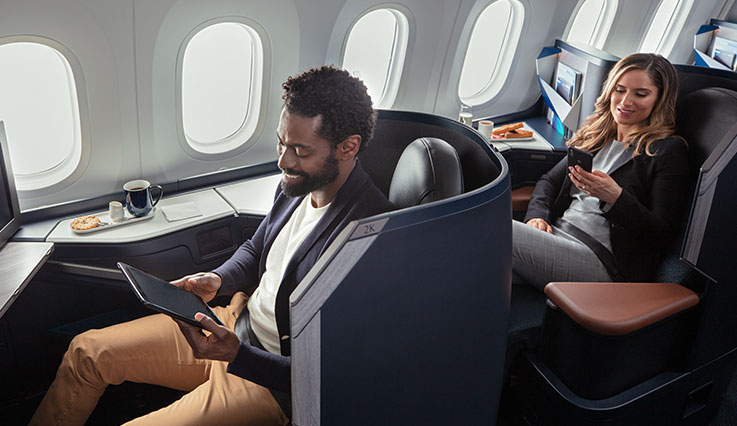 Profesionales sentados en cubículos personales de la cabina Business en el Boeing 787 Dreamliner de WestJet.
