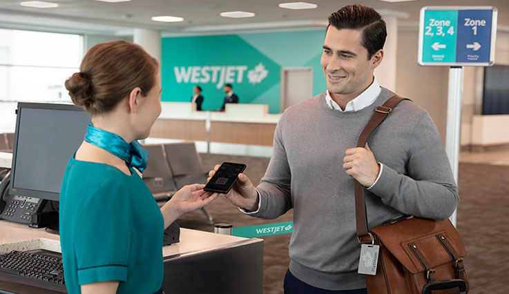 Vuelo de embarque del miembro Platinum de WestJet Rewards en la puerta utilizando una tarjeta de embarque electrónica.