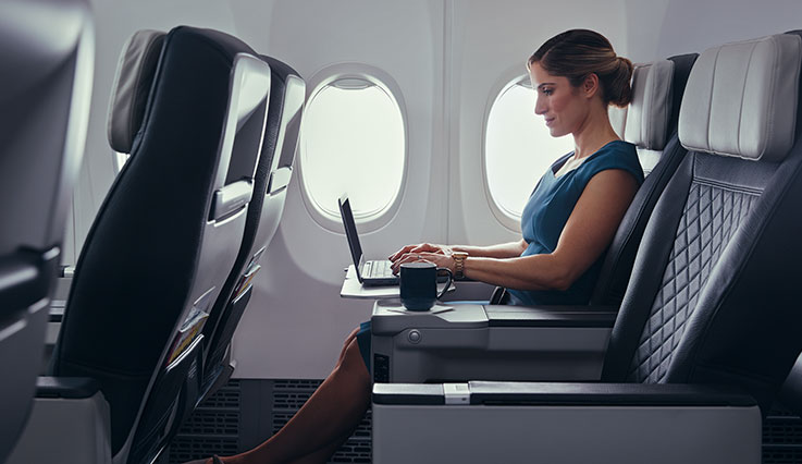 Invitado que utiliza una computadora portátil durante su vuelo en una cabina premium.