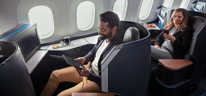 Professionals seated in Business cabin pods on the WestJet Boeing 787 Dreamliner.