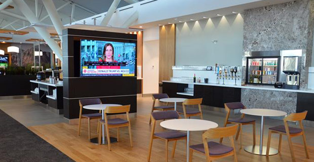 Televisión y asientos en Aspire Lounge International en el vestíbulo D del Aeropuerto de Calgary