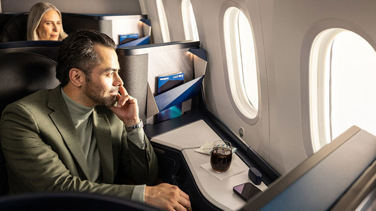 Woman enjoying a glass of champagne in business cabin