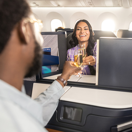 Two guests in Business Class airplane having a drink