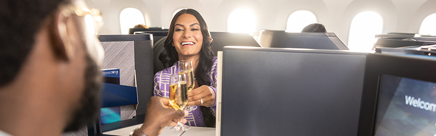 Two guests in Business Class airplane having a drink