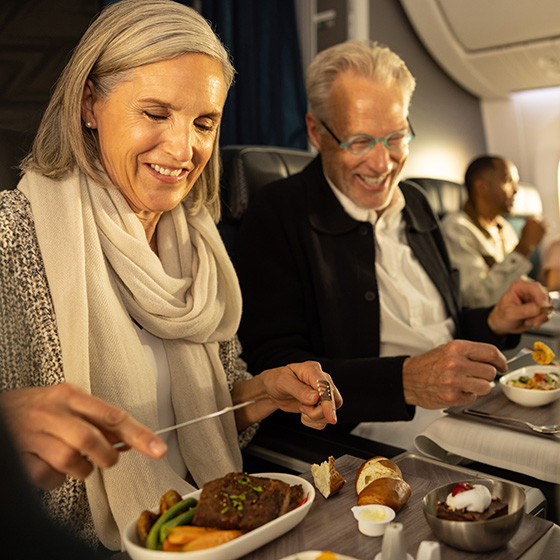 Couple eating a meal together on an airplane