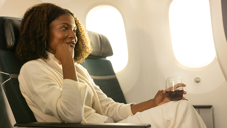 Une femme buvant un verre de vin dans un avion