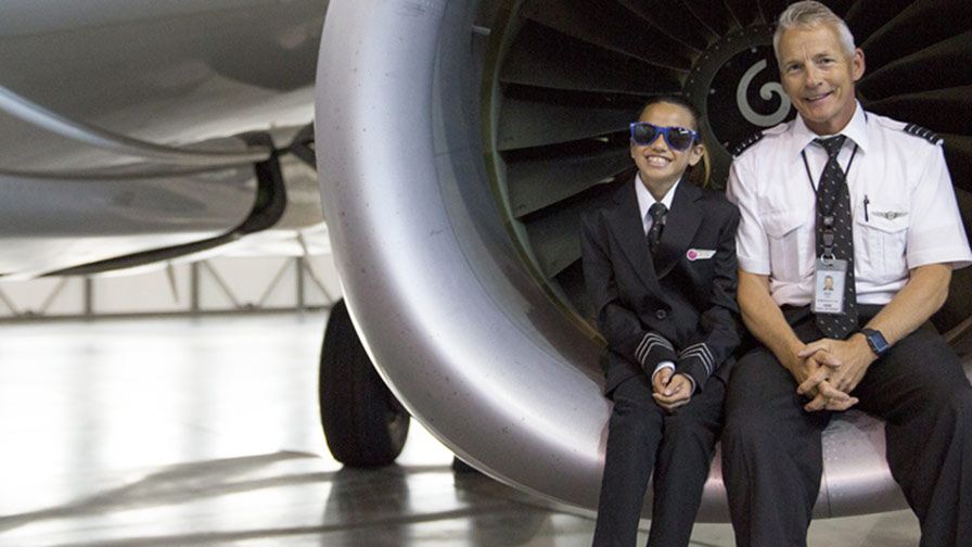 WestJet pilot and kid sitting in aircraft engine