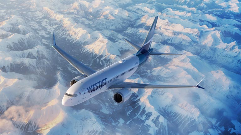 WestJet Boeing MAX 8 aircraft flying over Canadian Rocky Mountains in the morning