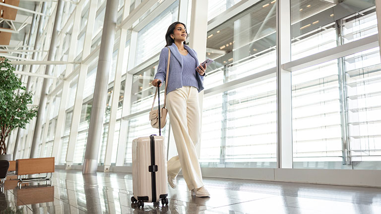 Une femme marchant dans l’aéroport avec une valise