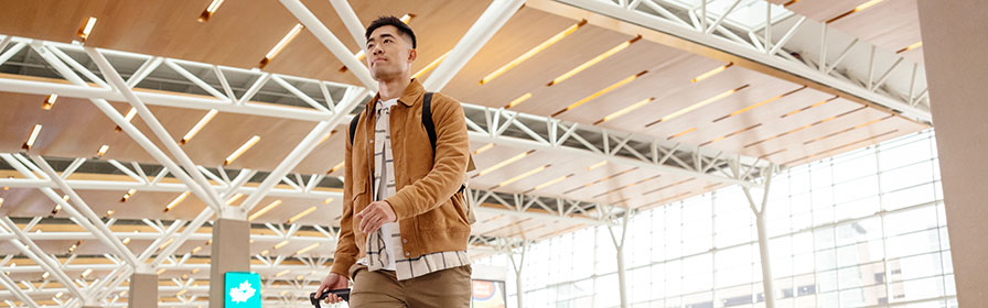 Businesswoman walking in airport with suitcase
