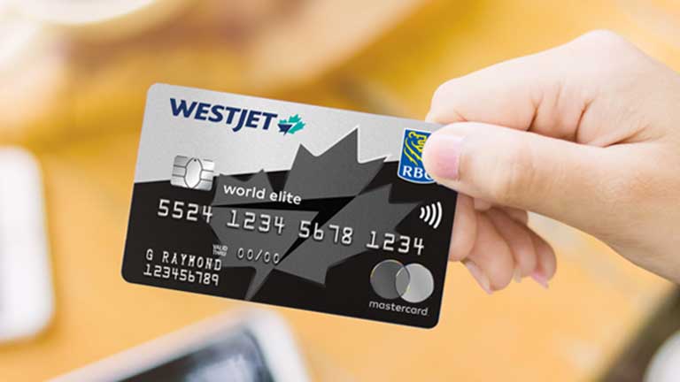 Une main tenant une carte WestJet Mastercard