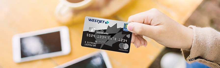 Guest holding WestJet RBC® World Elite Mastercard‡ in hand. 