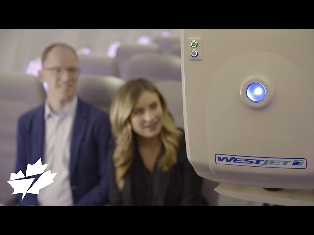 Two people staring at Ralph the robot