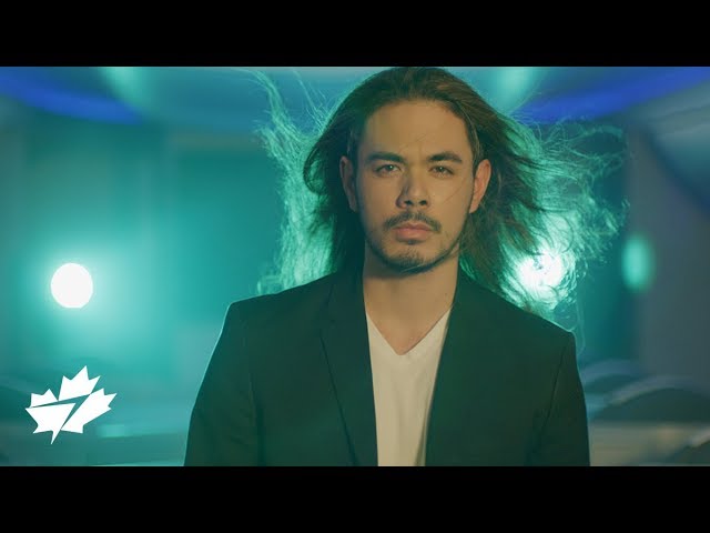 Man with hair flowing and neon lights in the background