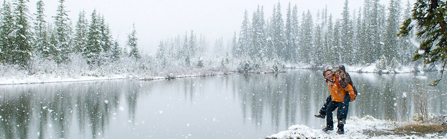 Couple walking along a snowy lake