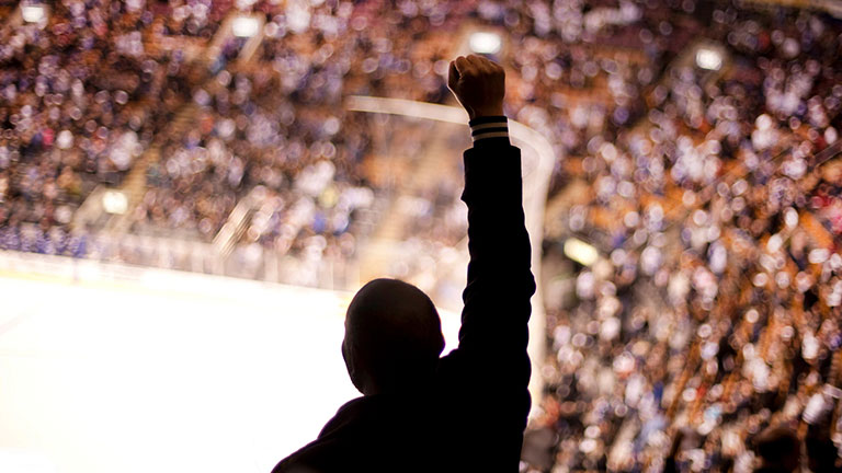 Fan at hockey game with fist in the air