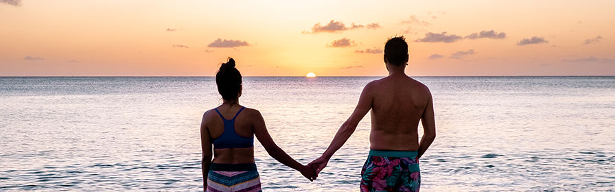 Un couple admire le coucher de soleil dans les Caraïbes
