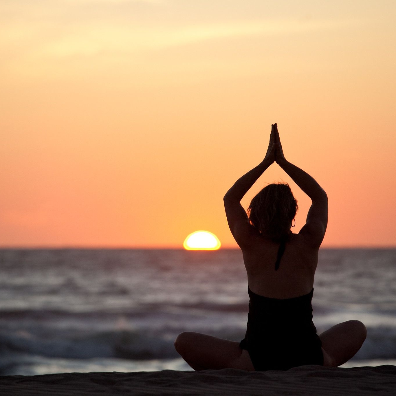 Une invitée faisant du yoga sur la plage