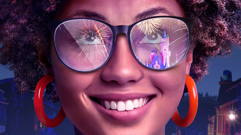  Smiling person with reflection of Disney castle in their eyeglasses 
