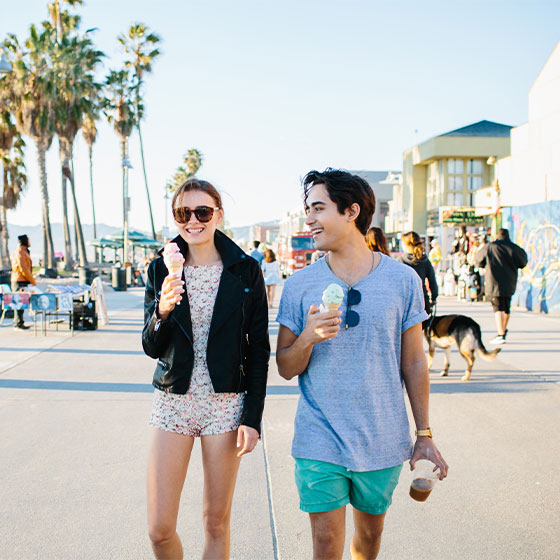 Un homme et une femme dégustant une crème glacée sur la plage de Venice.