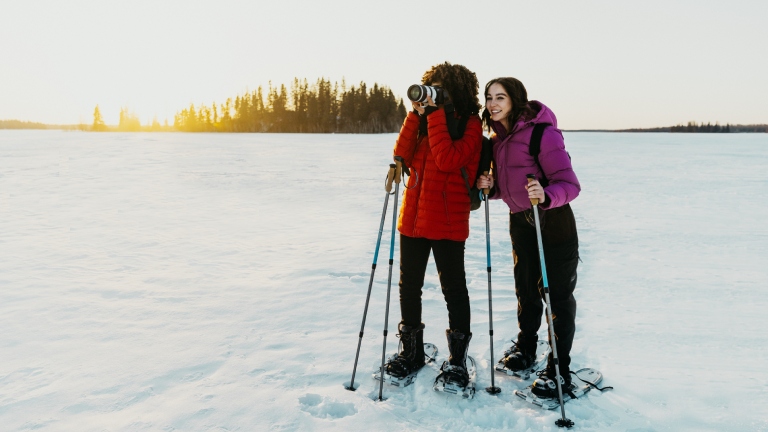 Snowshoers taking photos on frozen lake