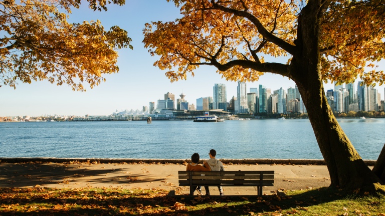 Couple assis sur un banc de parc au bord de l'eau à Vancouver