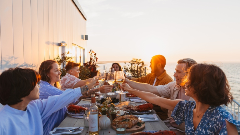 Des gens portant un toast lors d’un repas dans la baie de Shediac