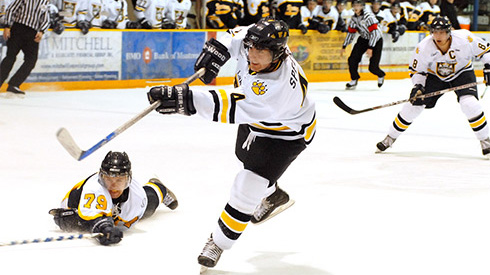 Hockey player shooting puck during Lakehead University Thunderwolves hockey game 
