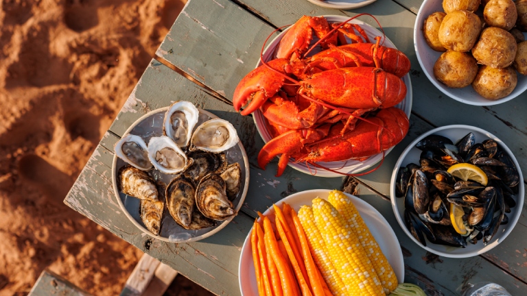 Overhead view of seafood on a picnic table at the beach