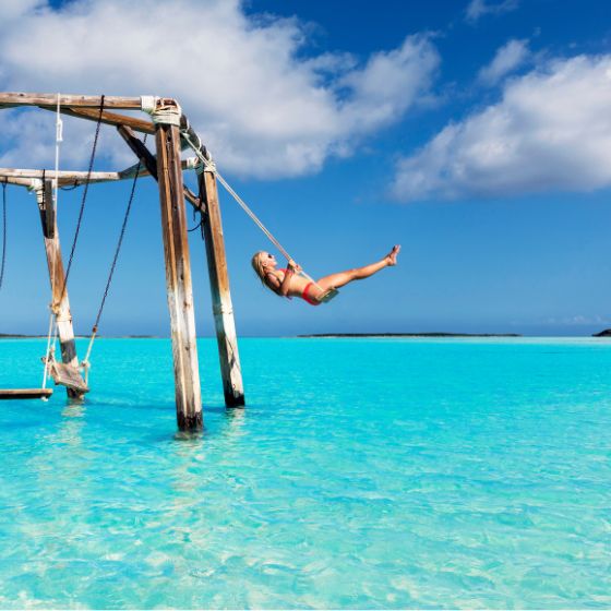 Woman swinging over the ocean