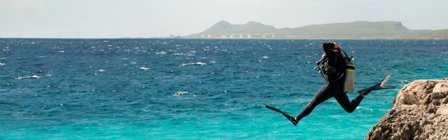 SCUBA diver jumping into water in Bonaire