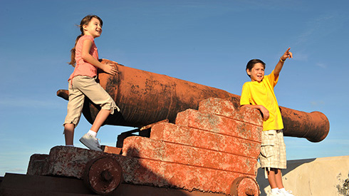 Enfants jouant avec le canon de Fort Fincastle, à Nassau