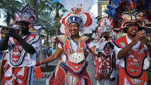 Festive dancers and musicians at Junkanoo wearing red outfits