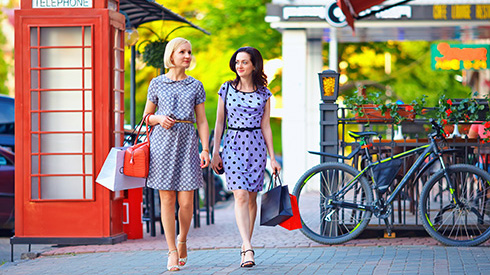 Two women walking past a red telephone booth