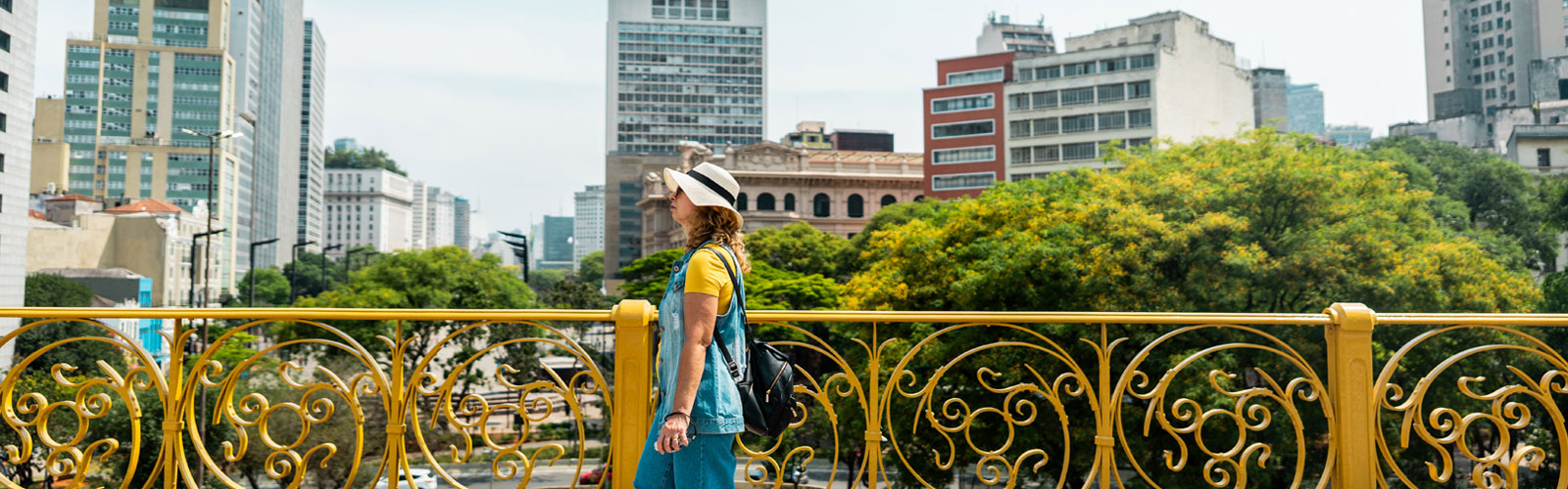 Woman walking along Viaduto do Cha with the city in the background.