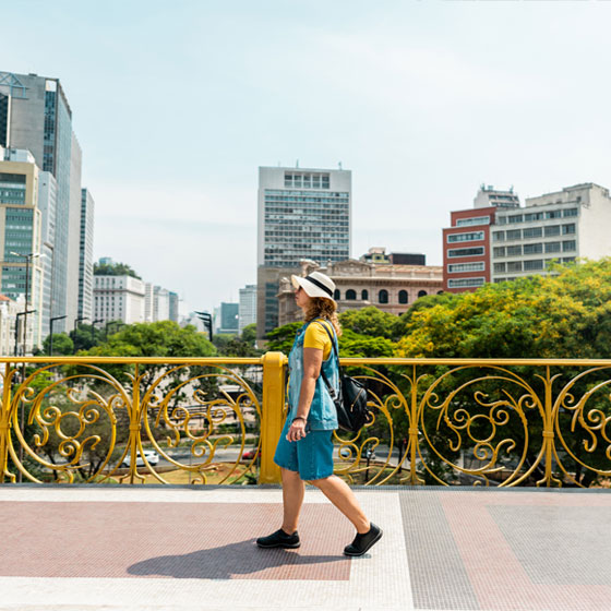 Femme marchant le long de Viaduto do Cha avec la ville en arrière-plan. 