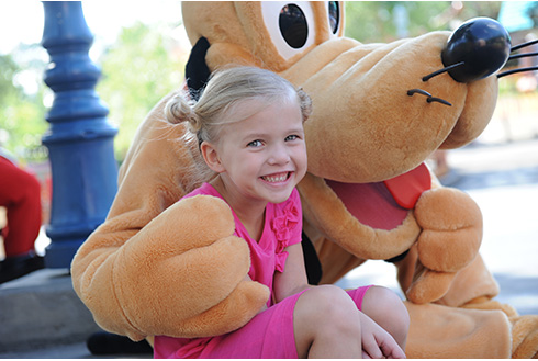 Pluto and a guest laughing at Walt Disney World