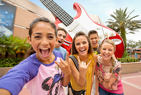 Group of guests smiling in front of the Rock ‘n’ Roller Coaster