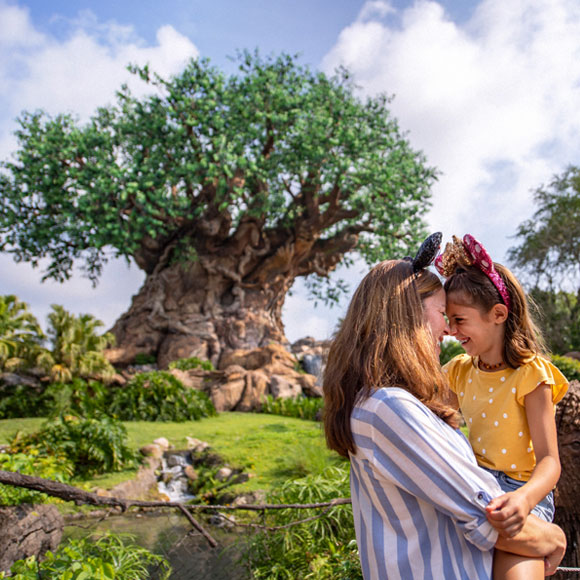 Mother and daughter in foreground of tree at Disney World
