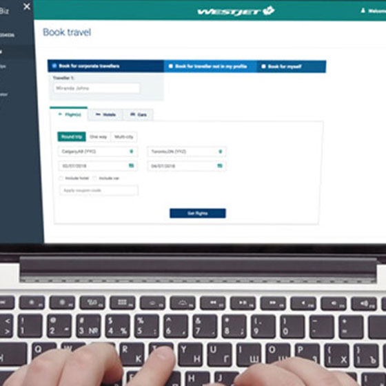 WestJet corporate booking tool on laptop.