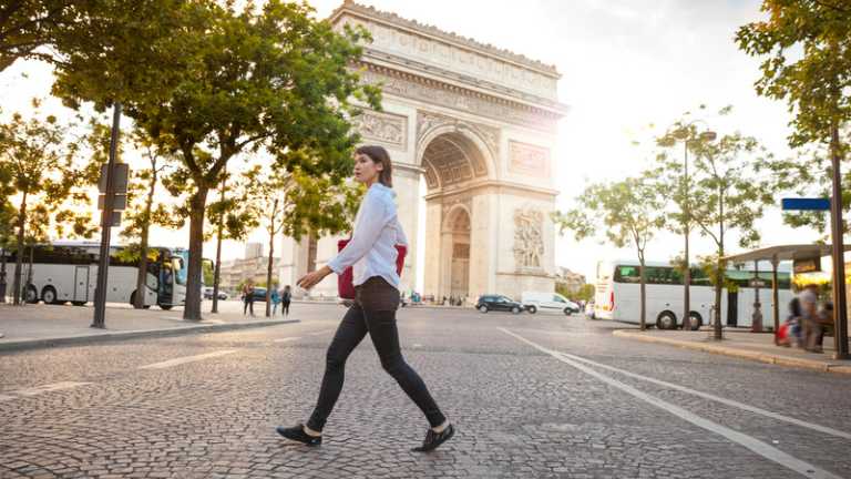 Person walking by the Arc de Triomphe