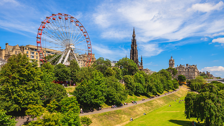 Travellers enjoying the park around Edinburgh's Festival Wheel.