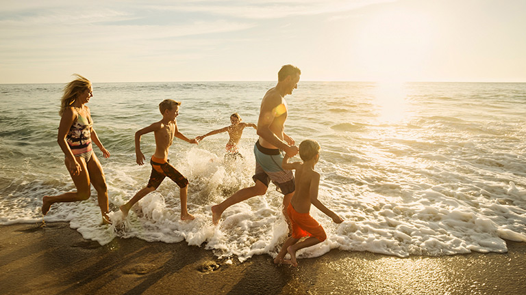 Family running on the beach
