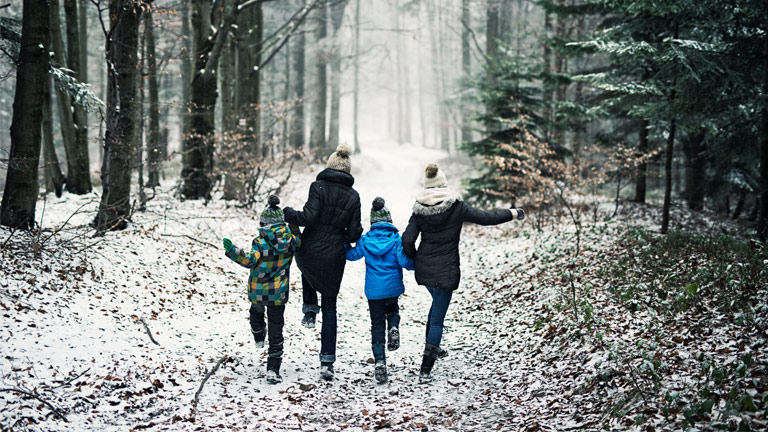 happy family running in winter forest