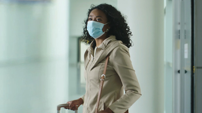 Woman wearing a mask waiting for her flight