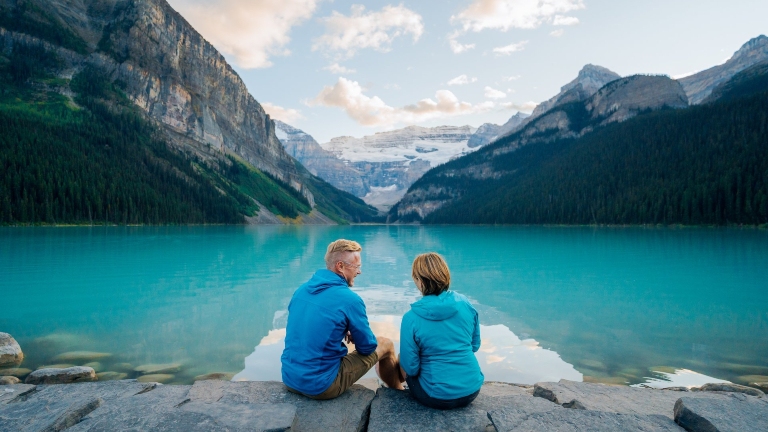 Couple assis sur un quai surplombant un lac de montagne