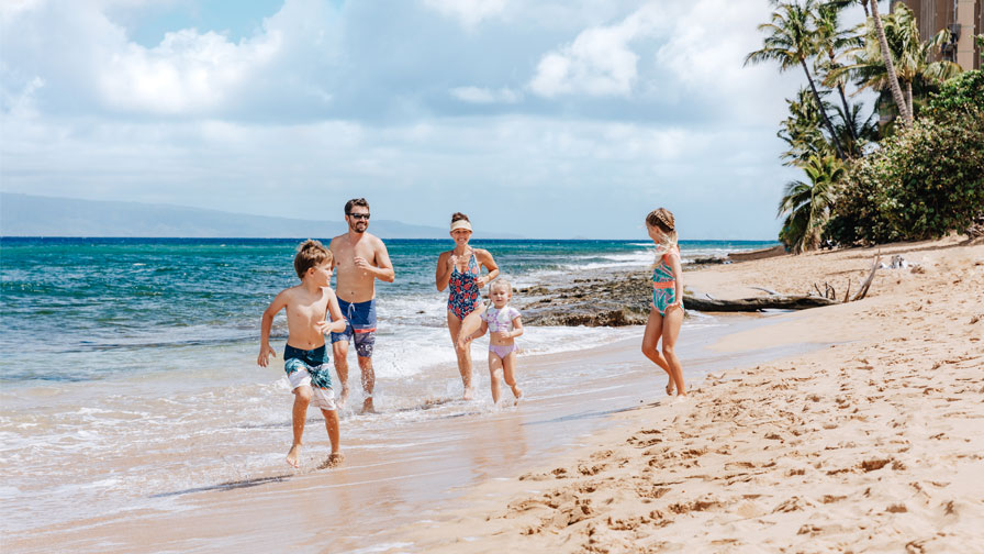 Family running on beach at Honua Kai Resort & Spa